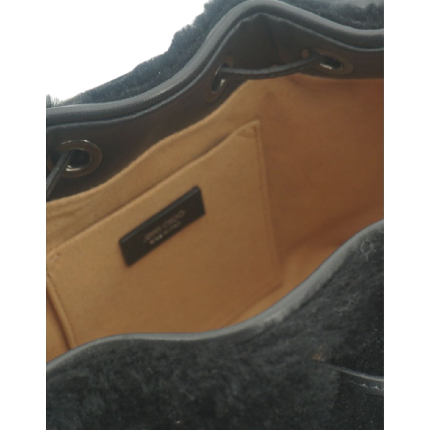 Interior view of Jimmy Choo black leather top handle and shoulder bag showing the main compartment and inner pocket.