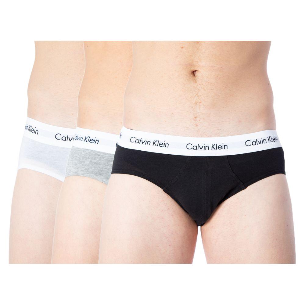 Three pairs of Calvin Klein men's cotton briefs in white, gray, and black with branded waistbands.