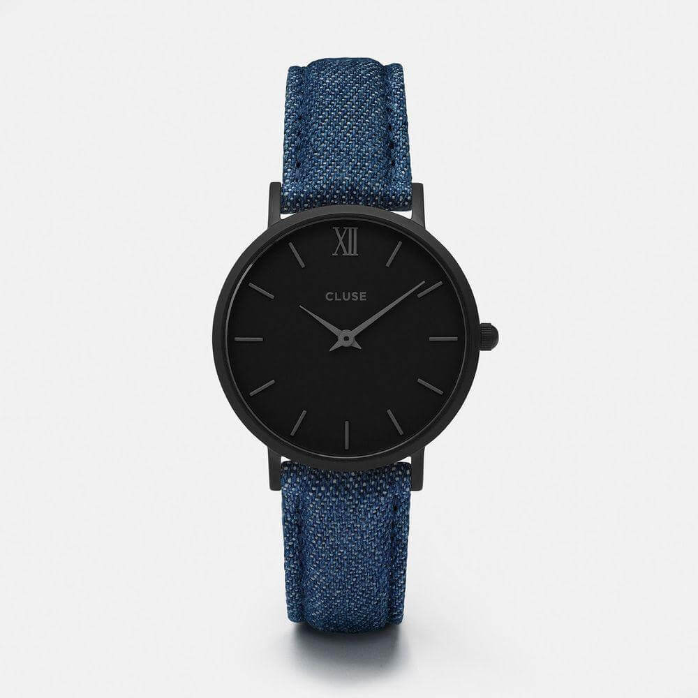 Cluse blue leather watch with a black stainless steel case, analog display, and buckle closure.