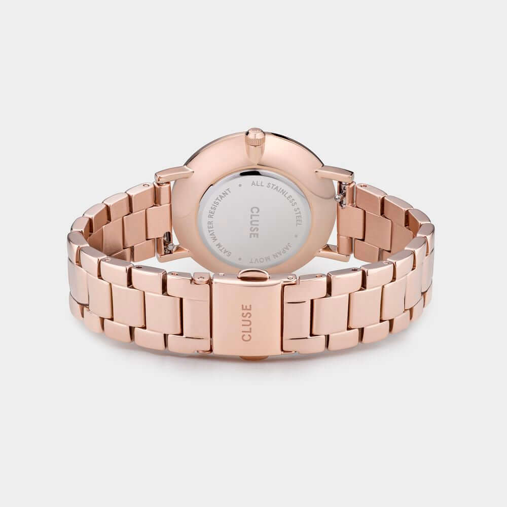 Cluse pink stainless steel watch with pressure clasp, seen from the back showcasing the quartz movement and mineral glass.