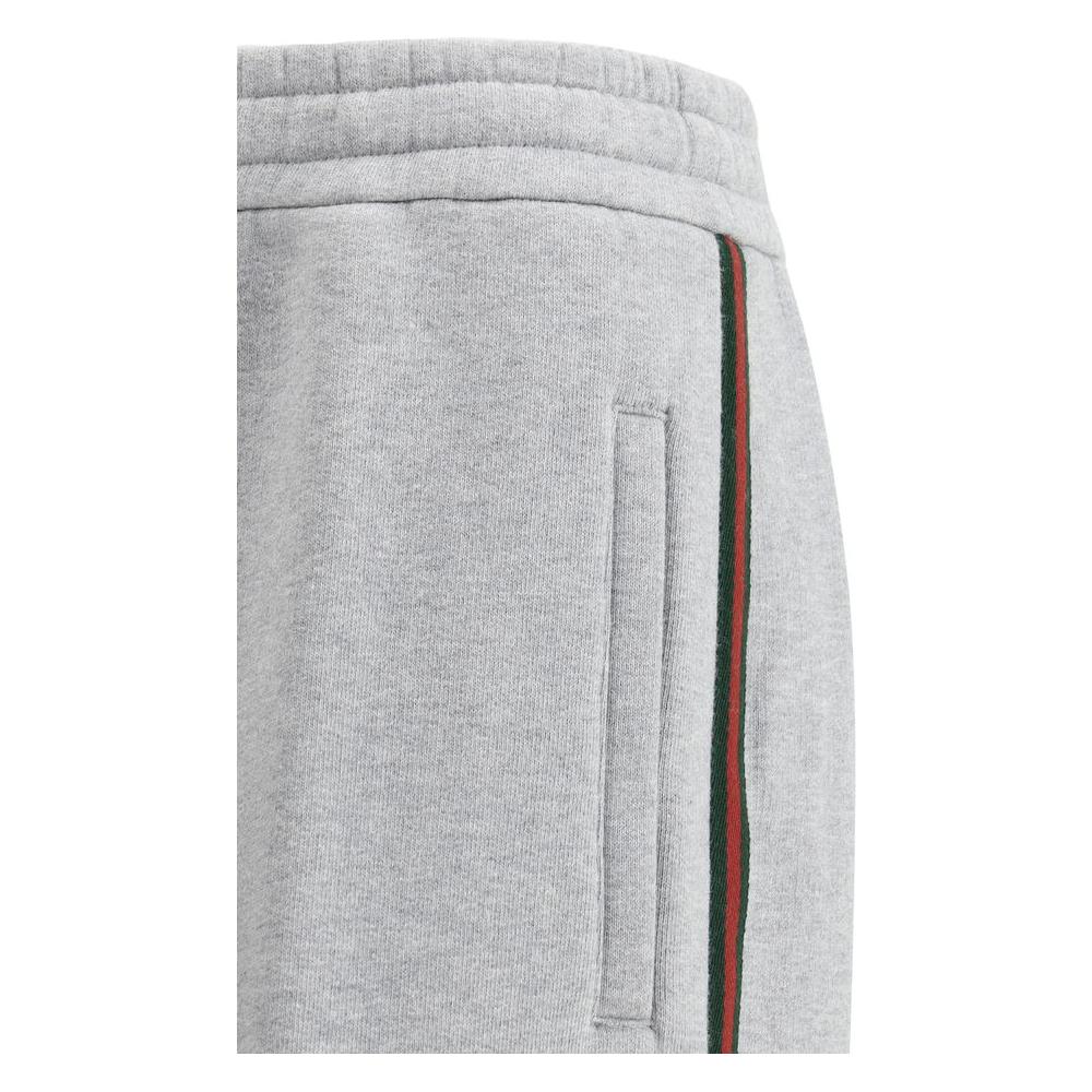Side view of Gucci cotton sweatpants with iconic colored side bands and monogram back pocket.