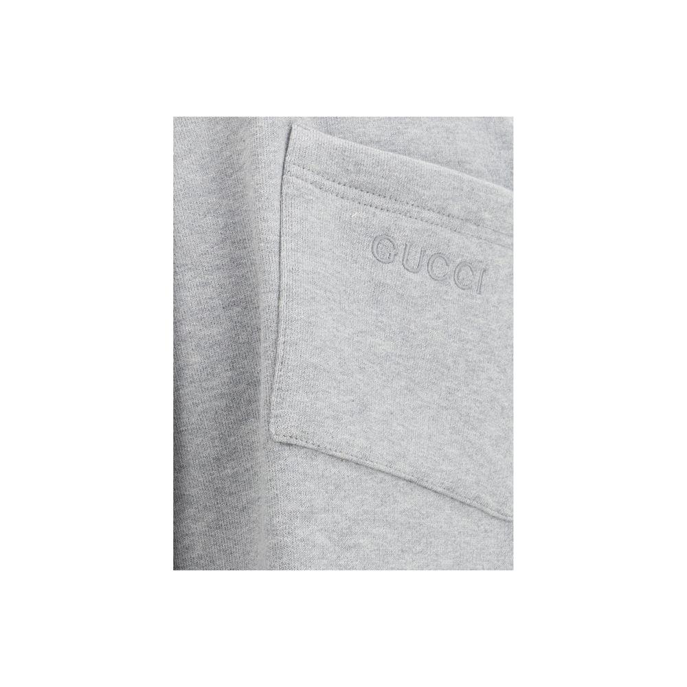 Close-up of Gucci sweatpants with monogram on back pocket, featuring iconic colored side bands.