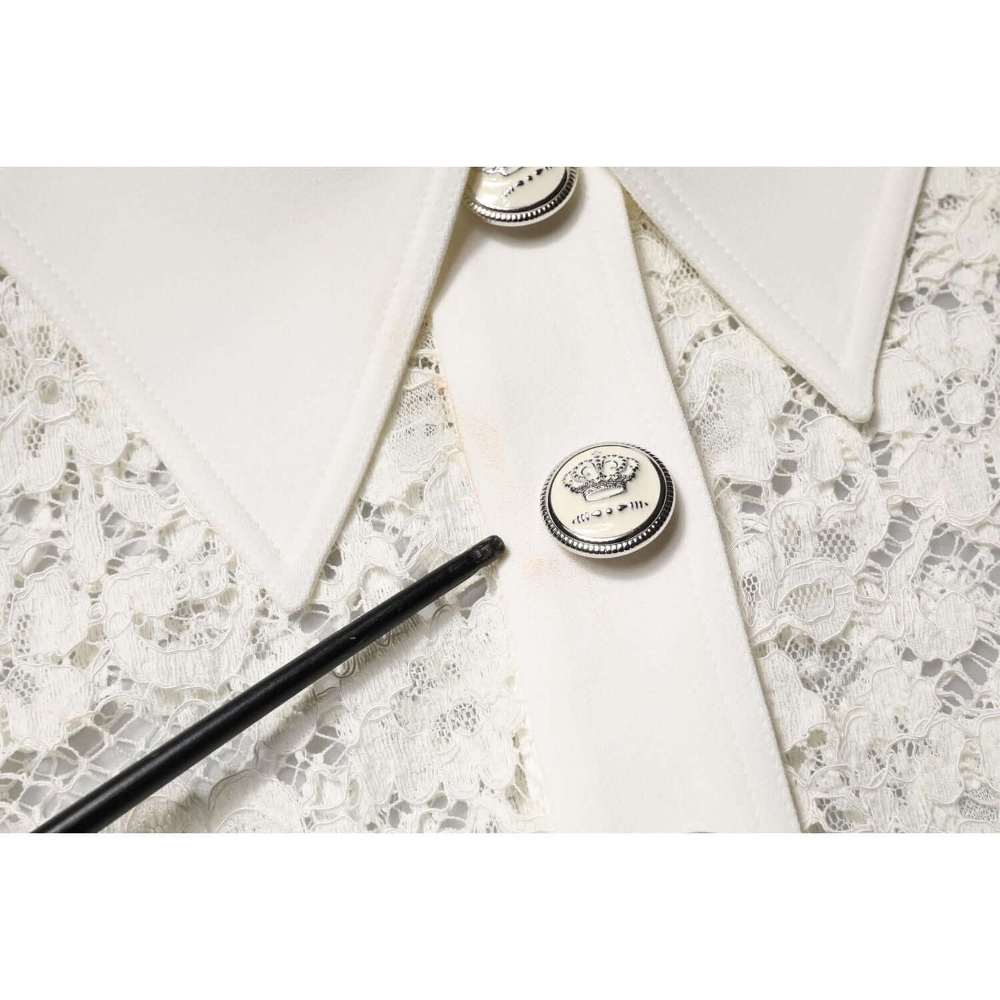 Close-up of Dolce & Gabbana white floral lace dress with button and minor makeup stains