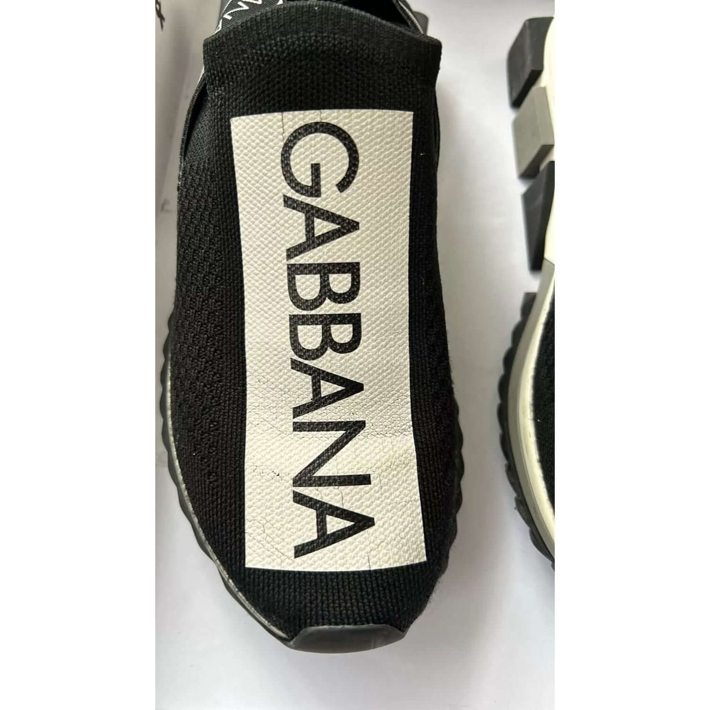 Dolce & Gabbana Sorrento black and white sock sneakers with logo print, close-up of shoe detail.