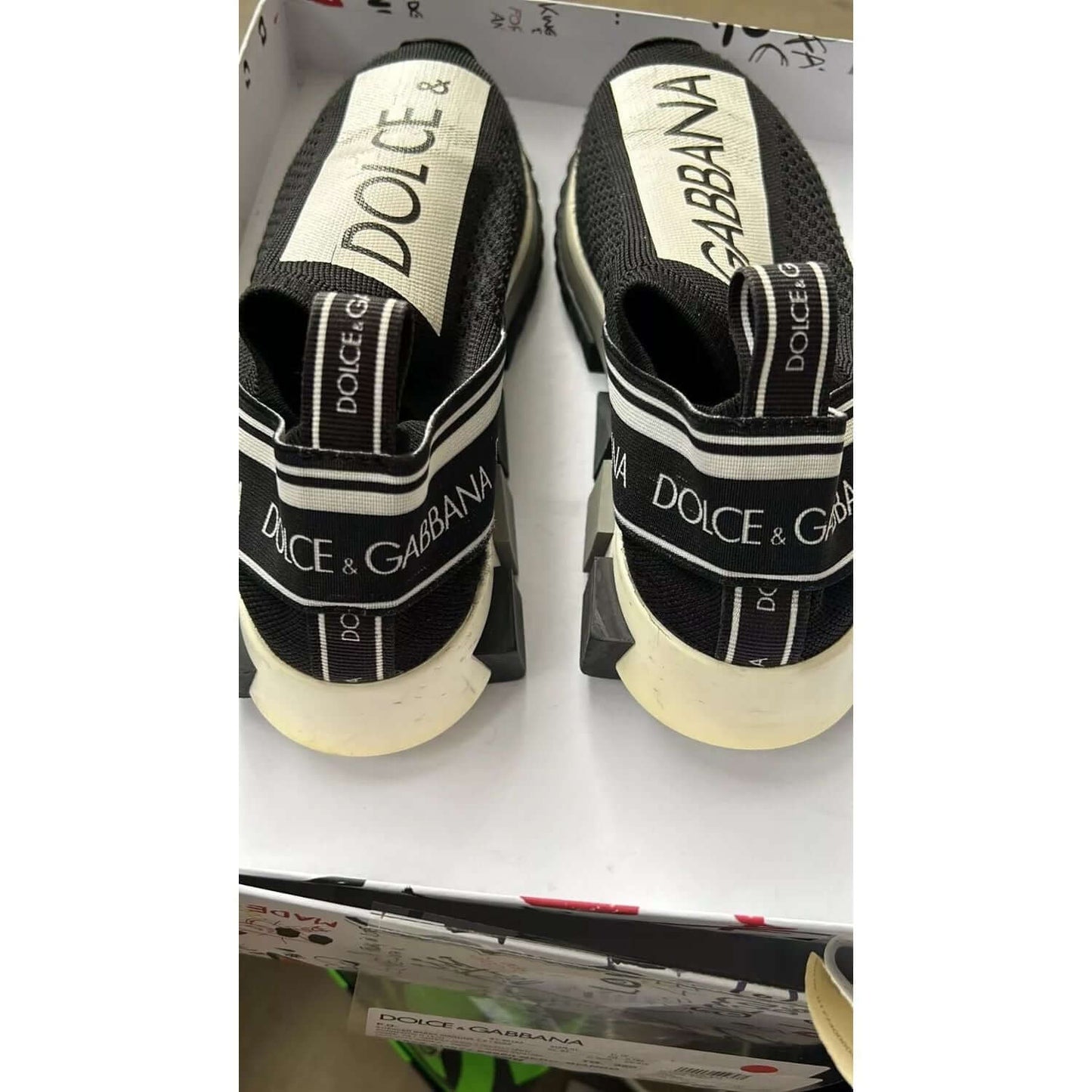 Dolce & Gabbana Sorrento black white slip-on sneakers with logo detailing, adorned with a fabric pull strap and rubber sole.