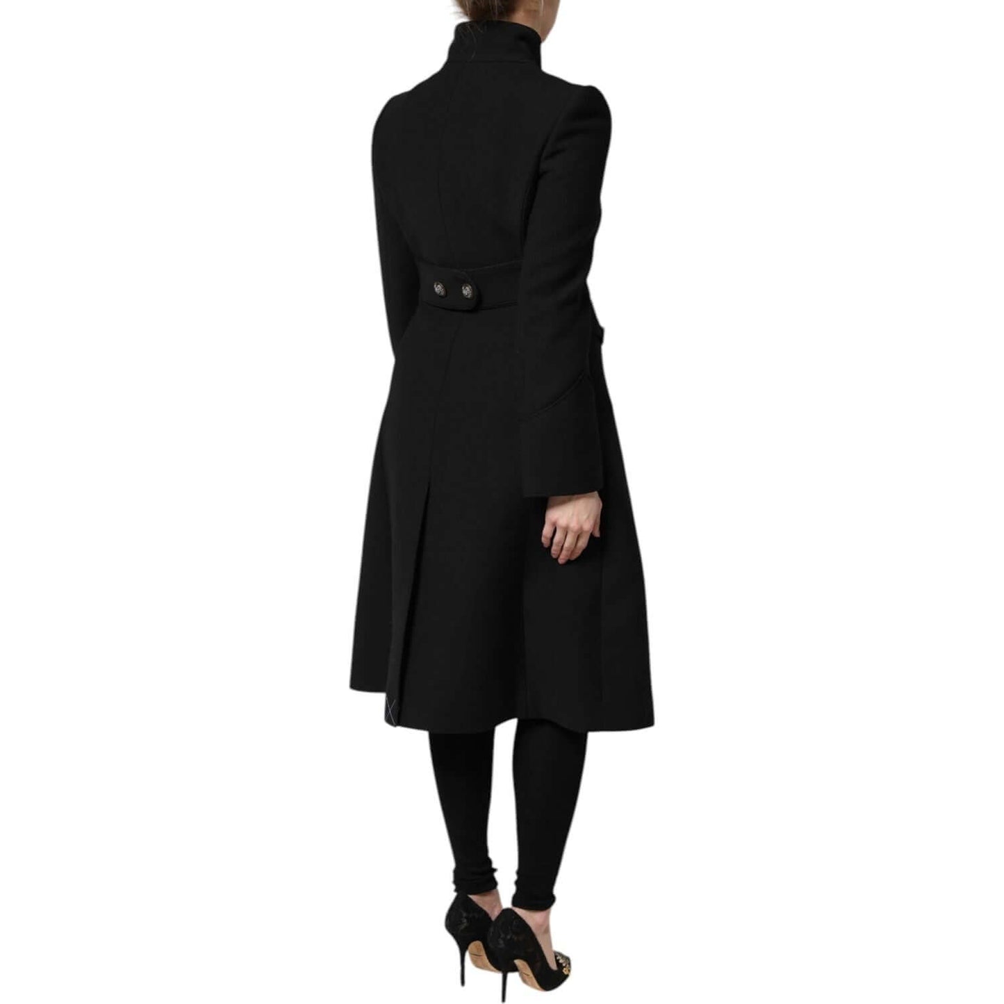 Back view of Dolce & Gabbana black wool single-breasted trench coat with button details, worn by a model in high heels.