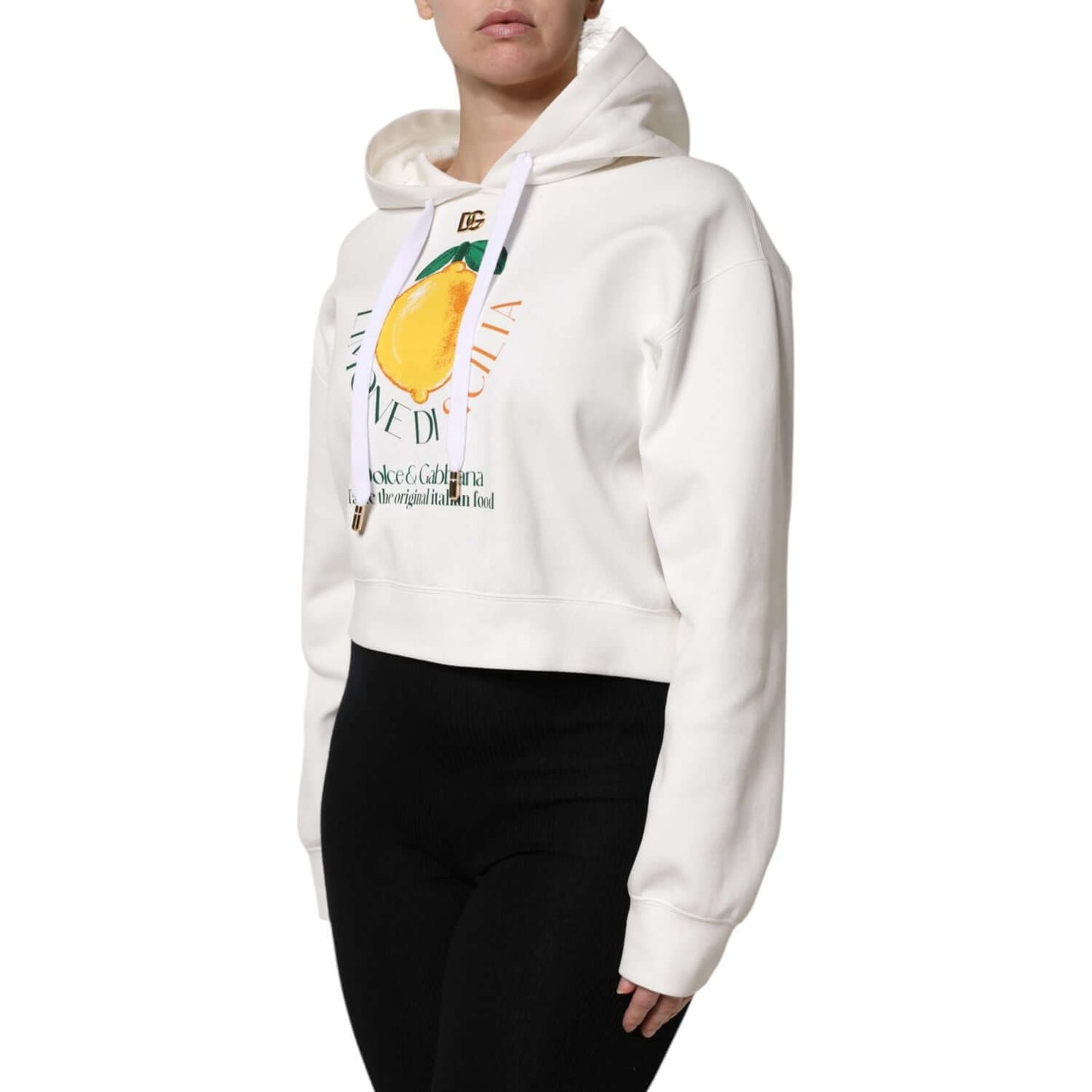 Dolce & Gabbana ivory cotton hooded pullover sweater with lemon print, logo detail, made in Italy, side view on model wearing black pants.