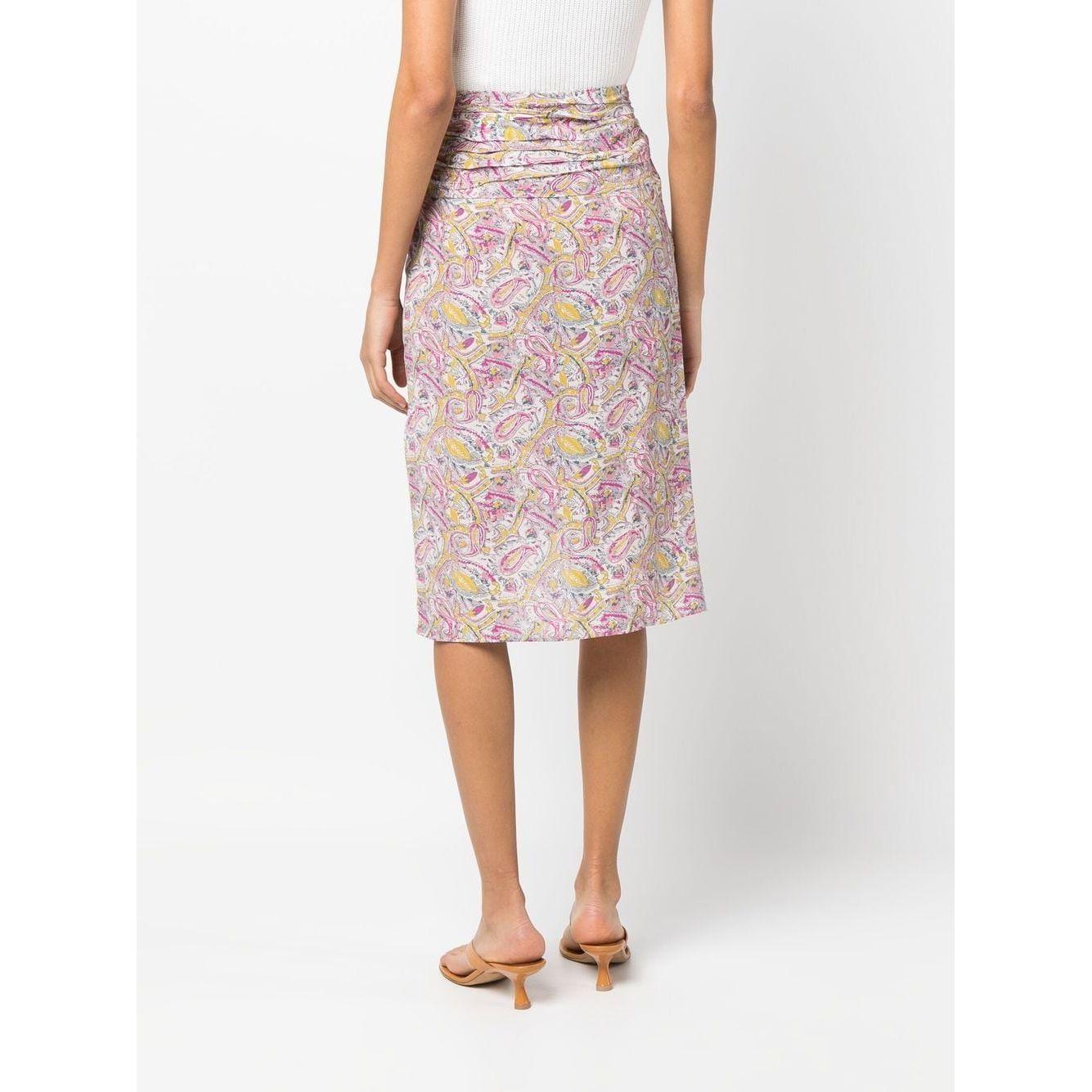 Model wearing Iro Skirts Beige with graphic ruched knee-length design, ecru and pink silk blend, viewed from the back.