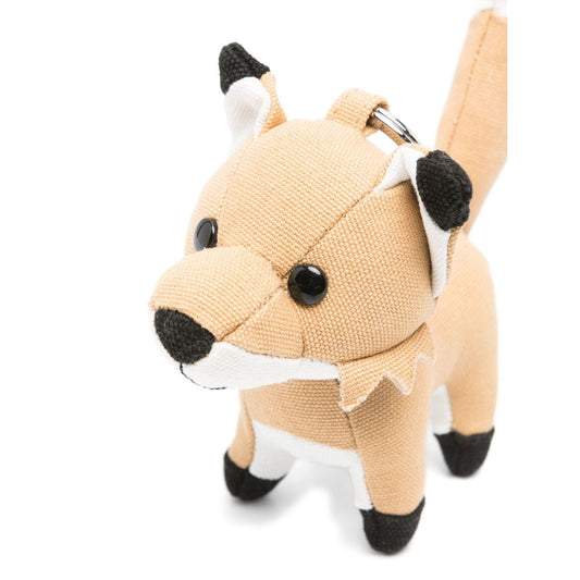 Maison Kitsuné Fox bag charm with engraved logo and pop-up animal ears in light beige, showcasing the signature fox motif keyring attachment.