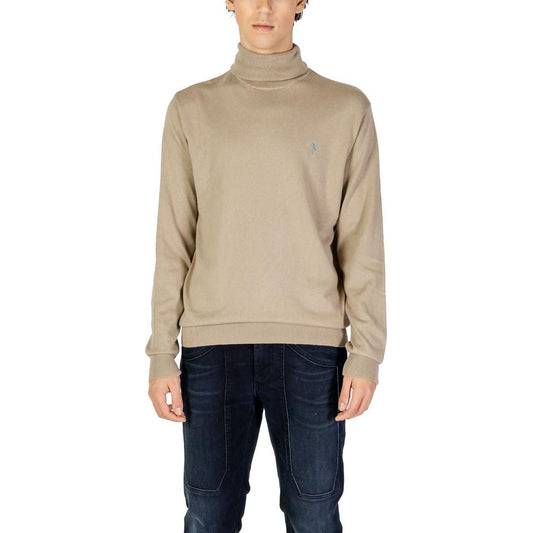 Man wearing U.S. Polo Assn. beige cotton turtleneck sweater with embroidered logo, perfect for formal and casual occasions.