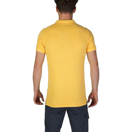 Back view of a man wearing a Superdry yellow cotton polo shirt, short sleeved, part of the Fall/Winter collection.