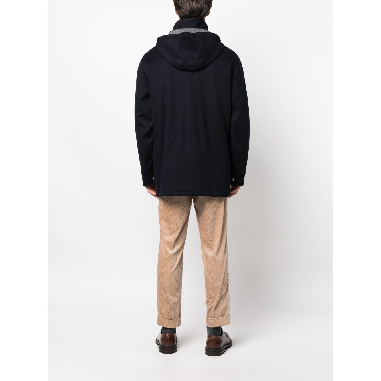 Back view of person wearing Brunello Cucinelli Detachable hood padded coat with brown pants, in a neutral background.