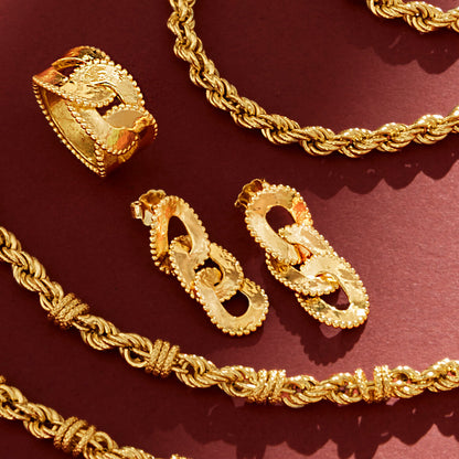 ETRUSCA JEWELS JEWELRY Mod. WSET00672.YG - 16 showcasing gold jewelry with intricate designs on a dark red background.