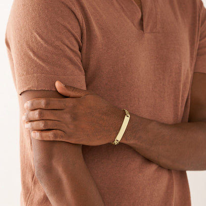 Man wearing FOSSIL JEWELS JEWELRY Mod. JF04465710 bracelet in a casual brown shirt, showcasing stylish accessory fashion.