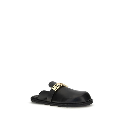 Moschino Black Calf Leather Bos Taurus Mules with gold logo plaque and round toe, perfect for adding a glamorous touch to any outfit.
