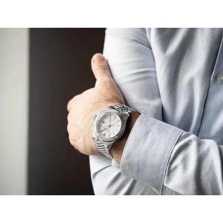 Gent wearing NAUTICA Mod. NAPPBS250 watch with quartz movement and mineral dial, 10 ATM water resistance, on wrist in office setting.