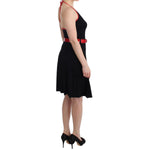 Woman wearing Roccobarocco Black belted palladio dress, knee-length, sleeveless, with red accents, side view.