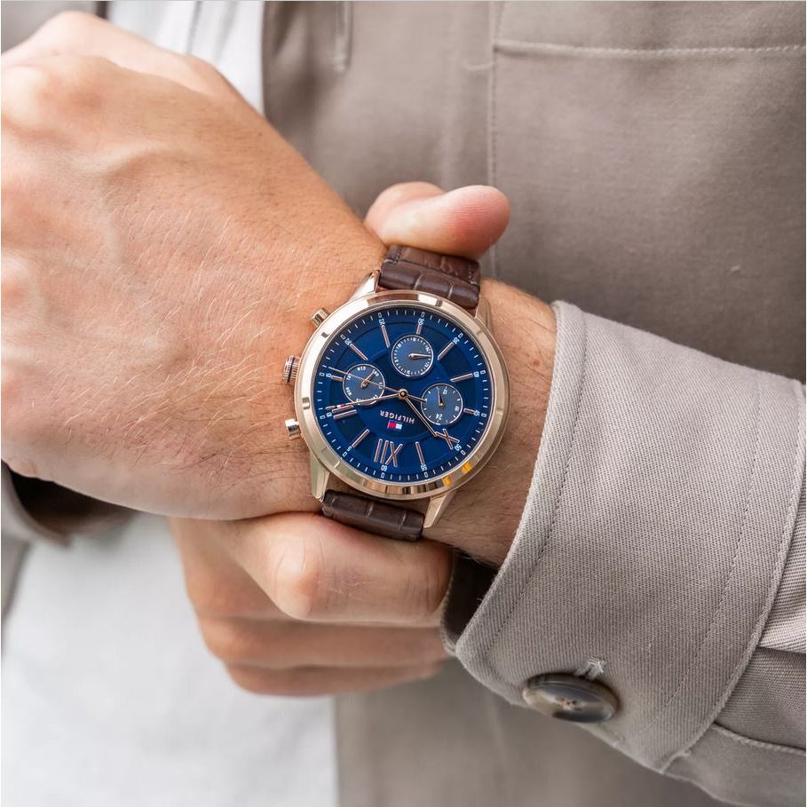 Alt Tag: Gentleman wearing TOMMY HILFIGER Mod. 1710526 watch with quartz analog movement and brown leather bracelet in official packaging.