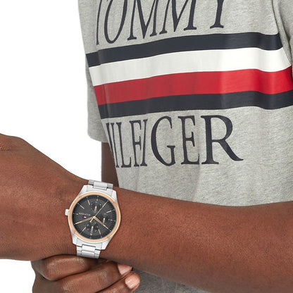 Gent's TOMMY HILFIGER Mod. 1710541 watch with quartz analog movement, 5 ATM water resistance, shown on wrist next to branded shirt.